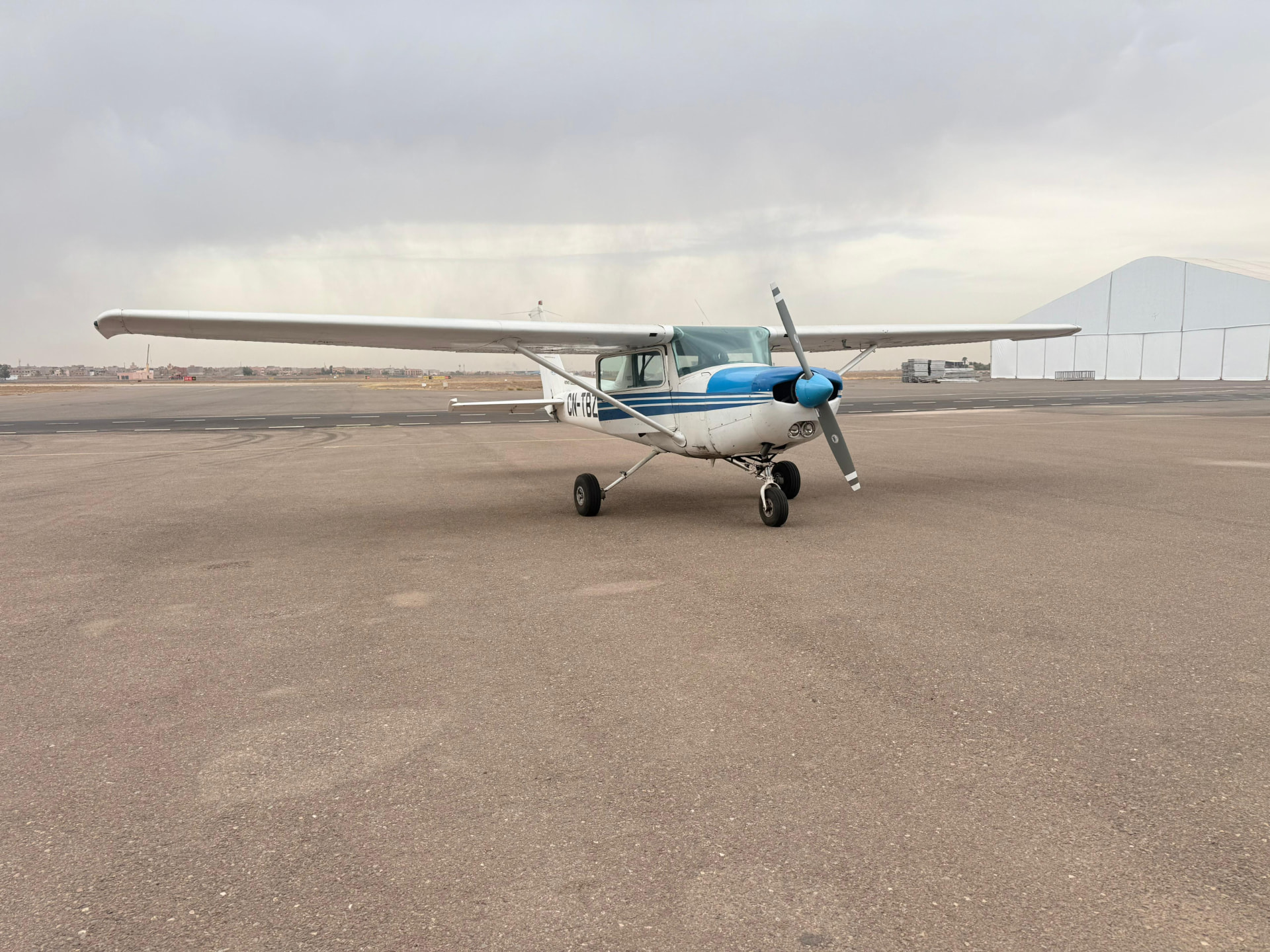 Le Cessna CN-TBZ vu de face sur l'aire de stationnement, ciel nuageux